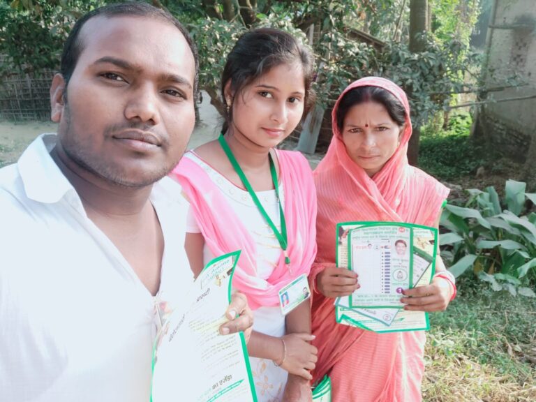 Political Mitra volunteer assisting local residents during a voter registration drive to encourage civic participation