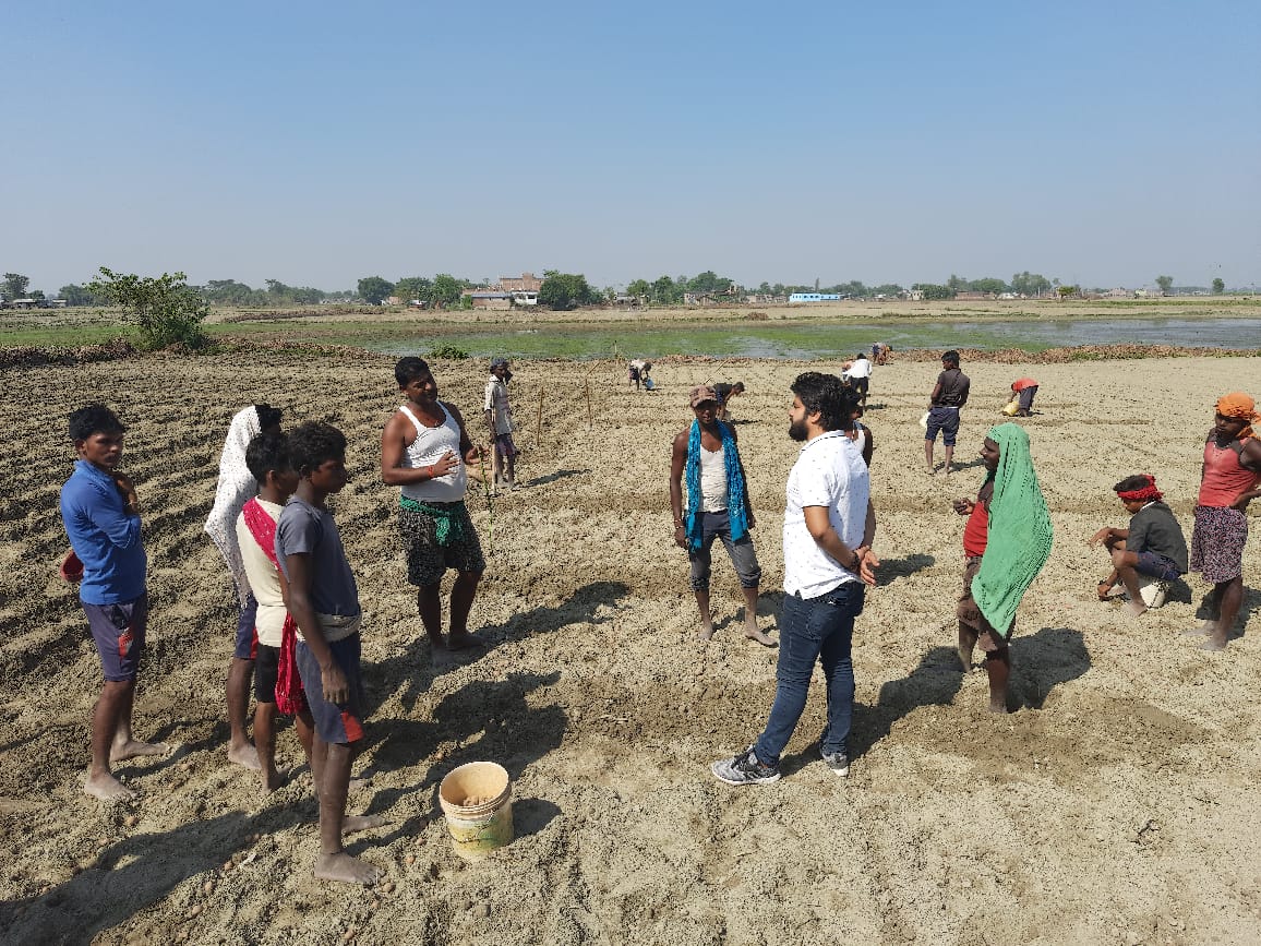 Bal Mukund Thakur speaking with a farmer in Bihar about government support for local agriculture